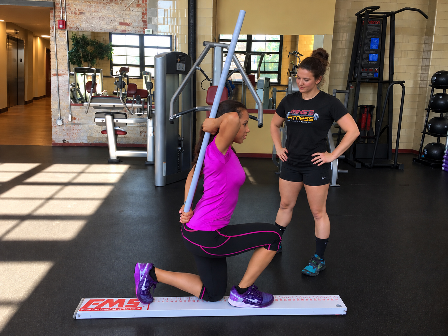 Trainer working one on one with a client during a free fitness assessment at Mike's Fitness JP in Jamaica Plain